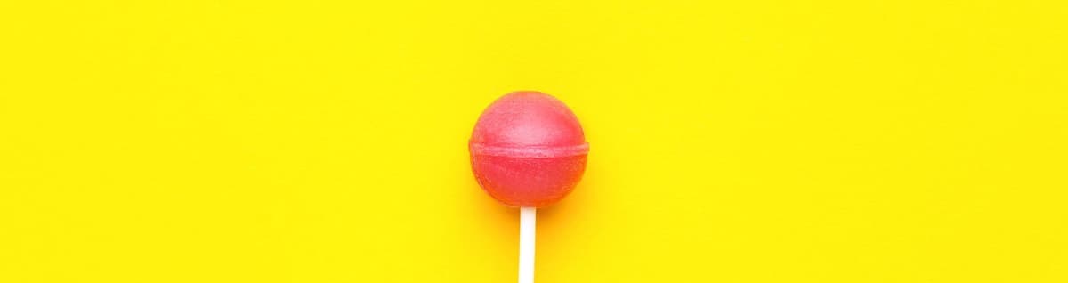 doce pirulito vermelho em fundo amarelo