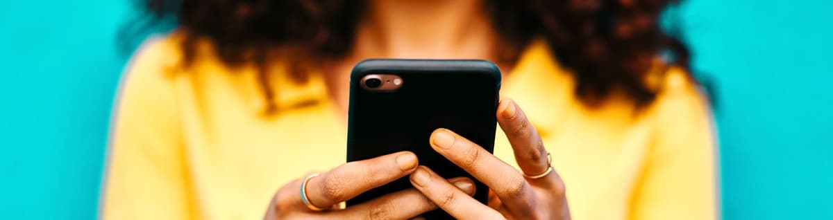 mulher sorrindo olhando para tela de celular