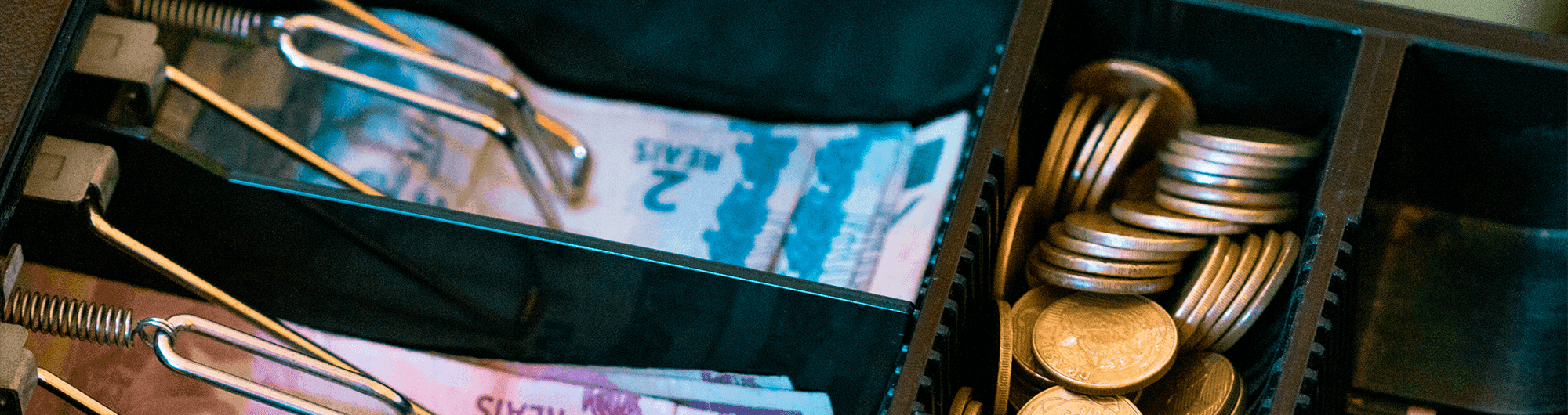 cédulas e moedas de real em caixa registradora 