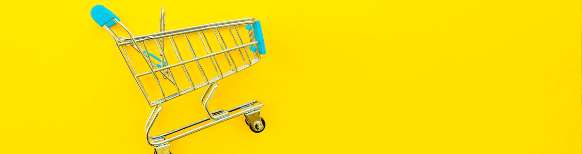 carrinho de supermercado em miniatura sob fundo amarelo