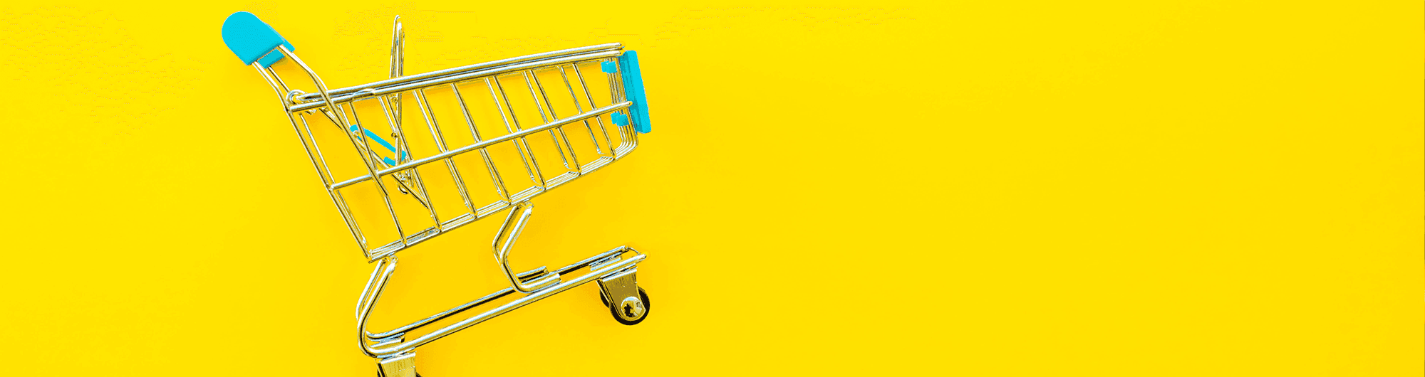 carrinho de supermercado em miniatura sob fundo amarelo
