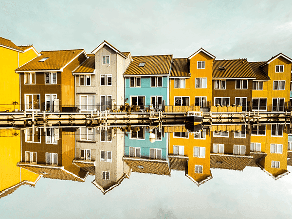 casas coloridas enfileiradas atrás de lago na europa 