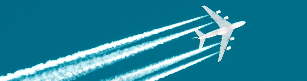 vista inferior de avião com rastro de percurso ao céu 