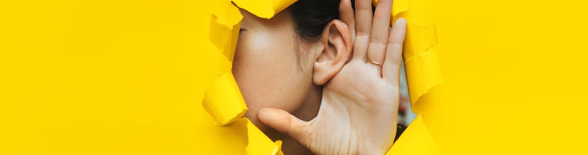 pessoa simulando ouvir em cenário amarelo 