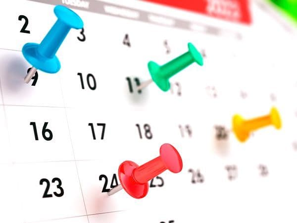 calendário marcado por alfinetes coloridos 