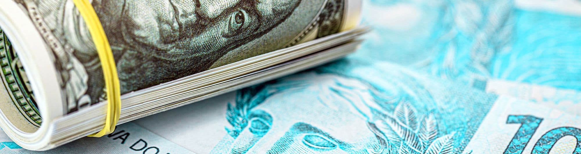 nota de dólar e de real sobrepostas