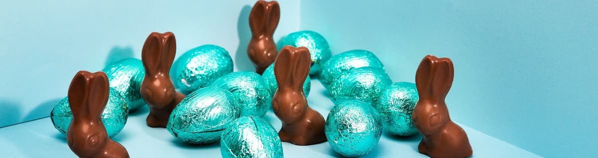 chocolate em formato de coelho e ovos sobre fundo azul