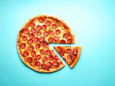 pizza inteira com fatia separada sobre fundo azul
