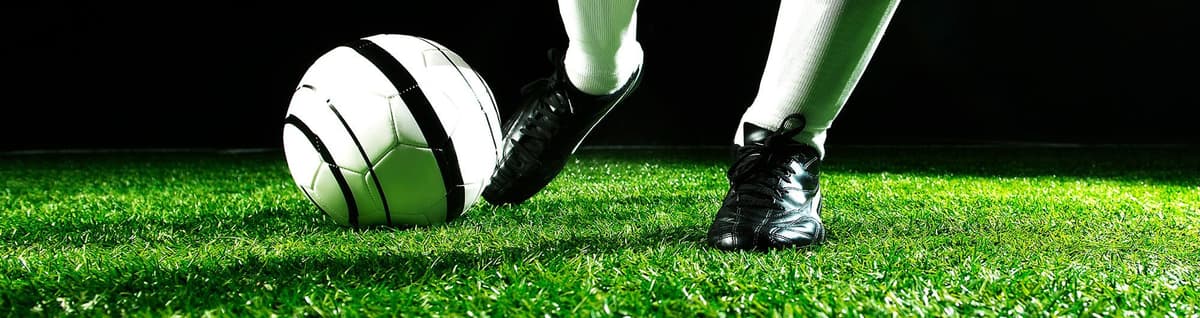 jogador de futebol arremeçando bola em campo