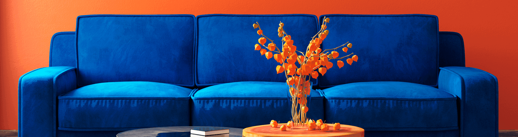 sofá azul em frente parede laranja