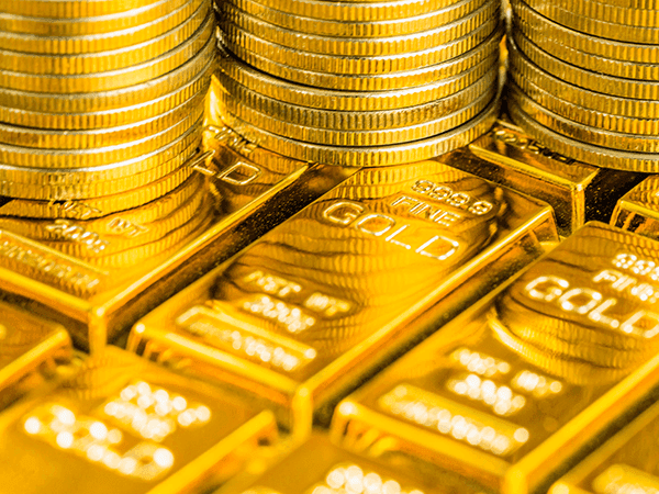 moedas e barras de ouro empilhadas 