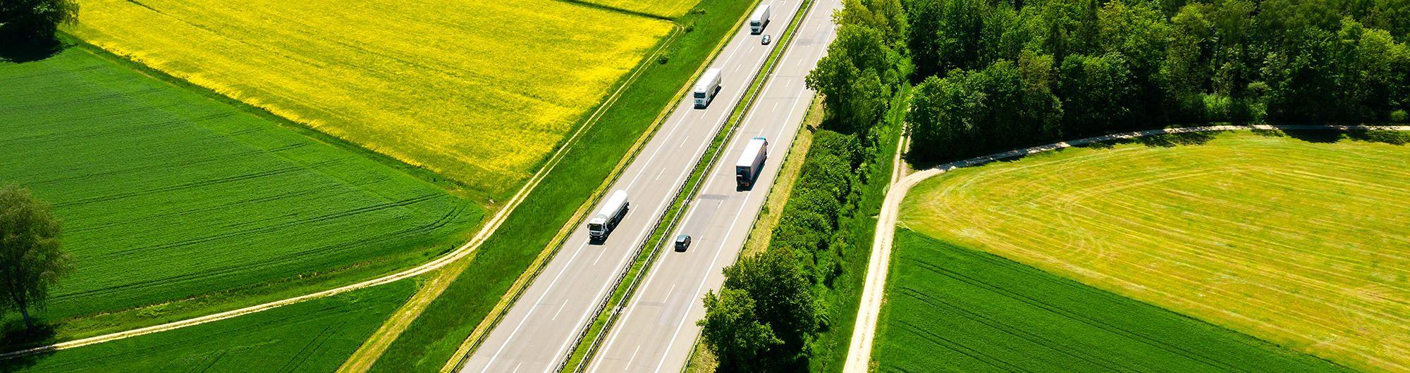 carros e caminhões passando por estrada em rodovia 