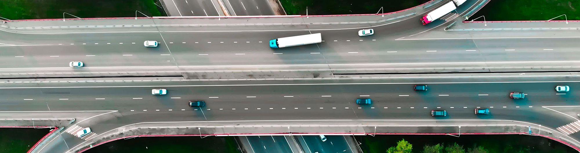 carros sob rodovia se movimentando em paisagem urbana