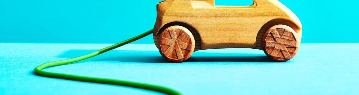 carro de madeira em miniatura sob fundo azul 