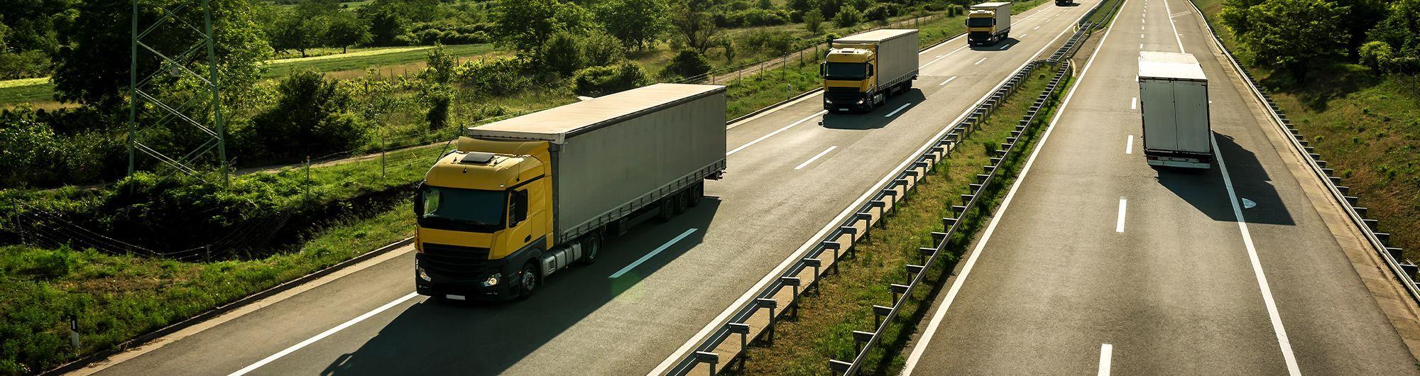 caminhões de transporte se movimentando em rodovia 