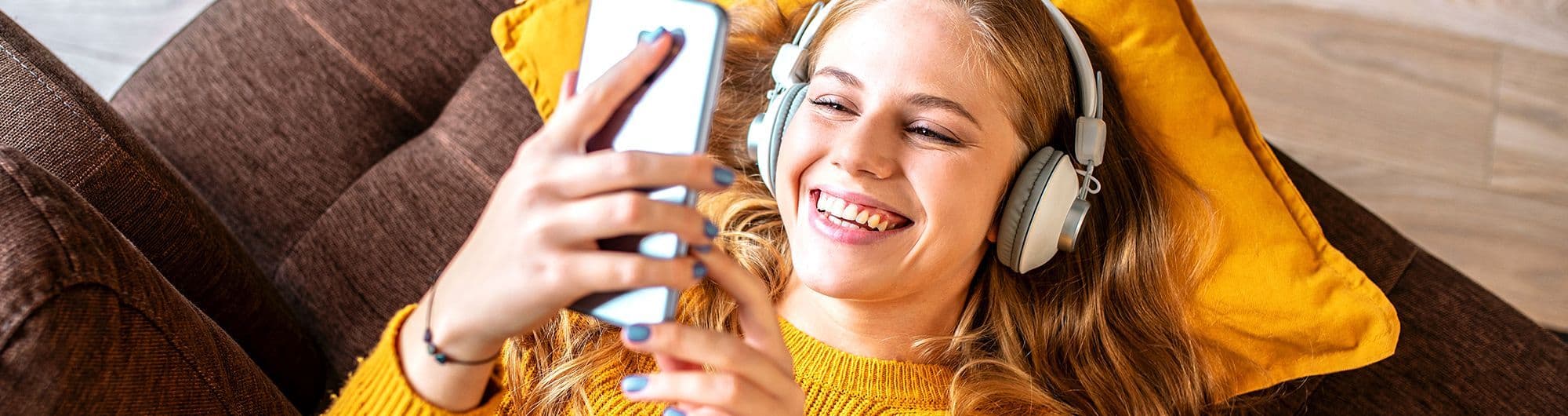 mulher sorrindo olhando para tela de celular