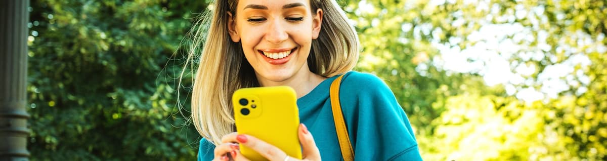 mulher sorrindo olhando para tela de celular