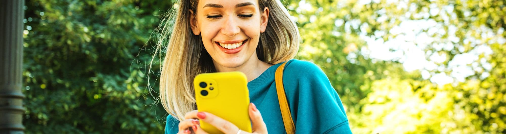 mulher sorrindo olhando para tela de celular