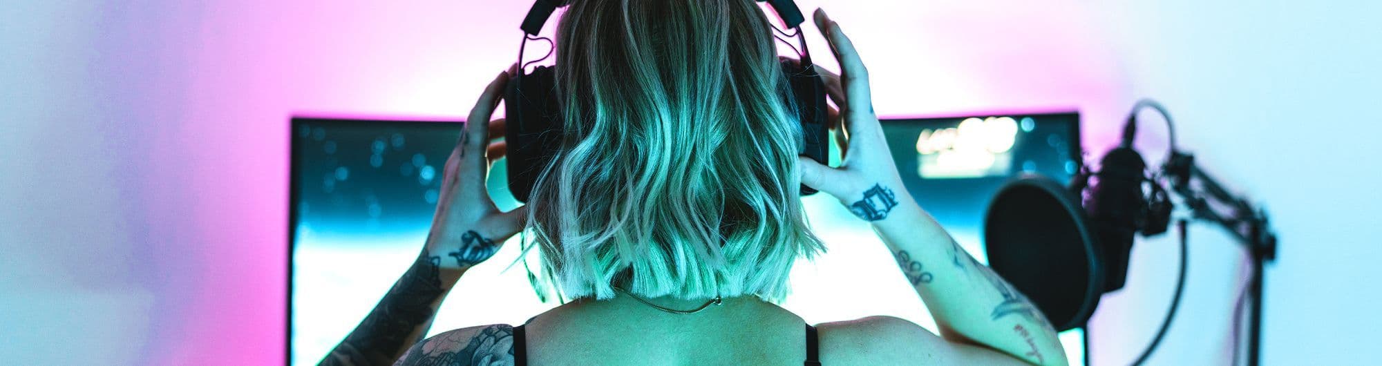 mulher em frente computador colocando fones de ouvido