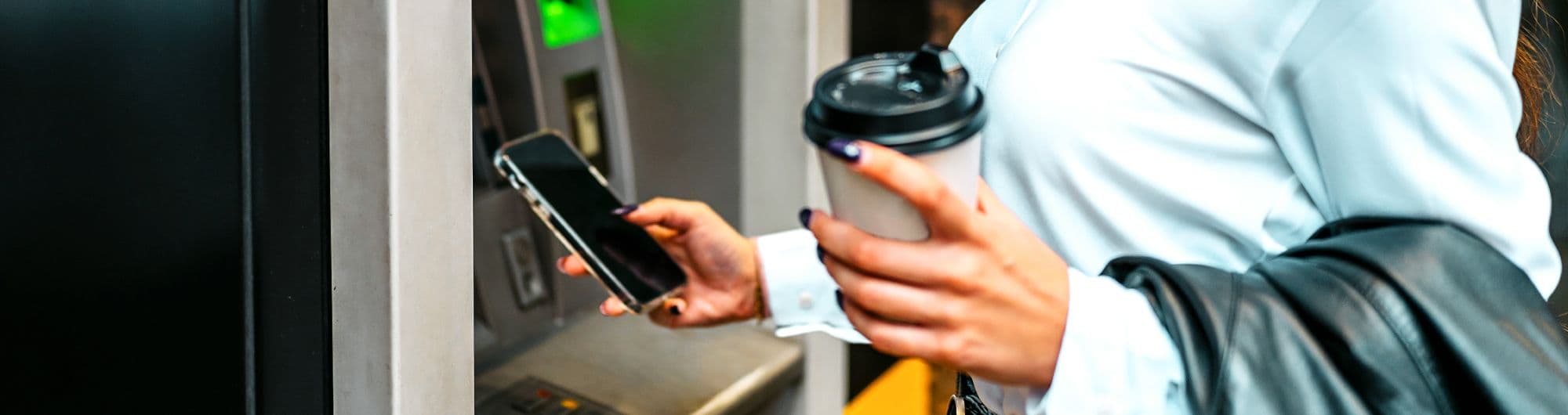 mulher fazendo pagamento em frente caixa de autoatendimento