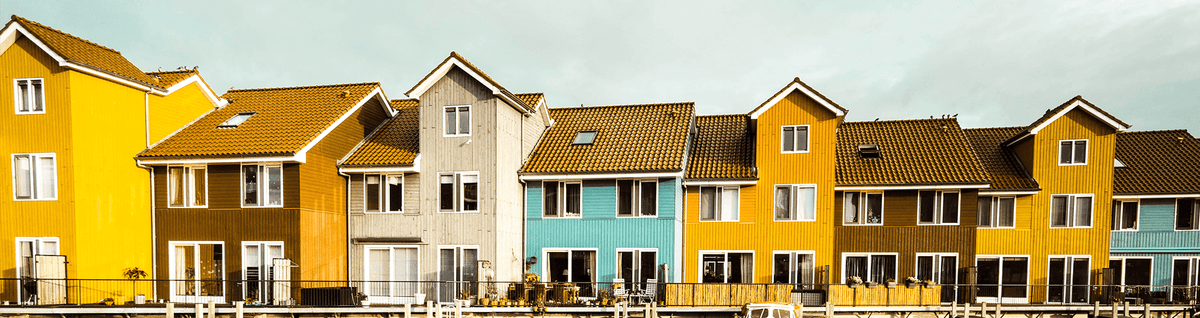 casas coloridas enfileiradas atrás de lago na europa