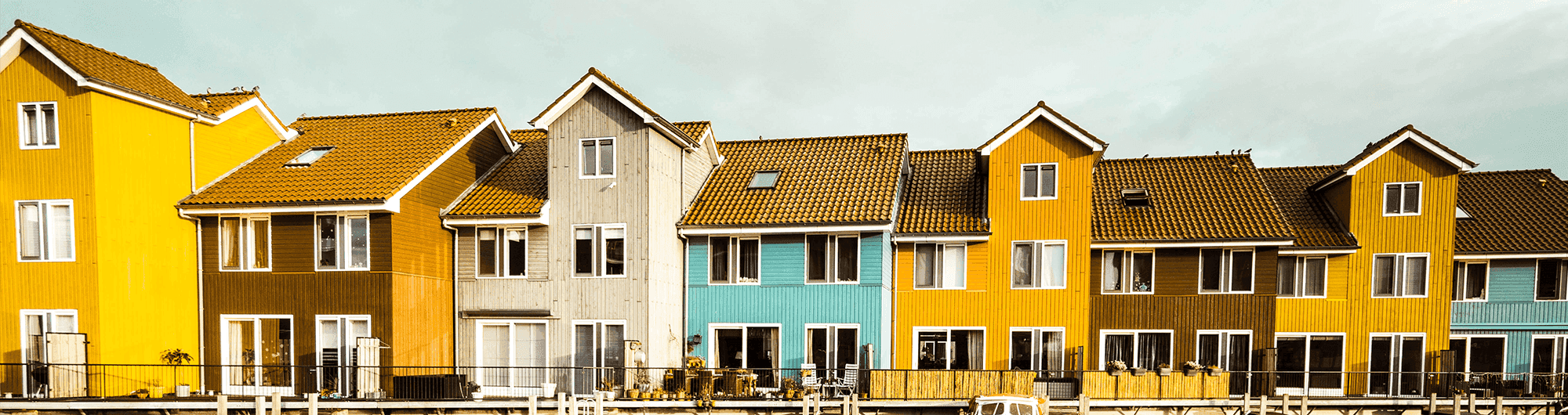casas coloridas enfileiradas atrás de lago na europa