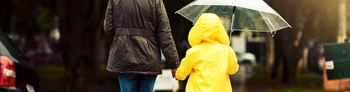adulto e criança com guarda chuva sob a cabeça
