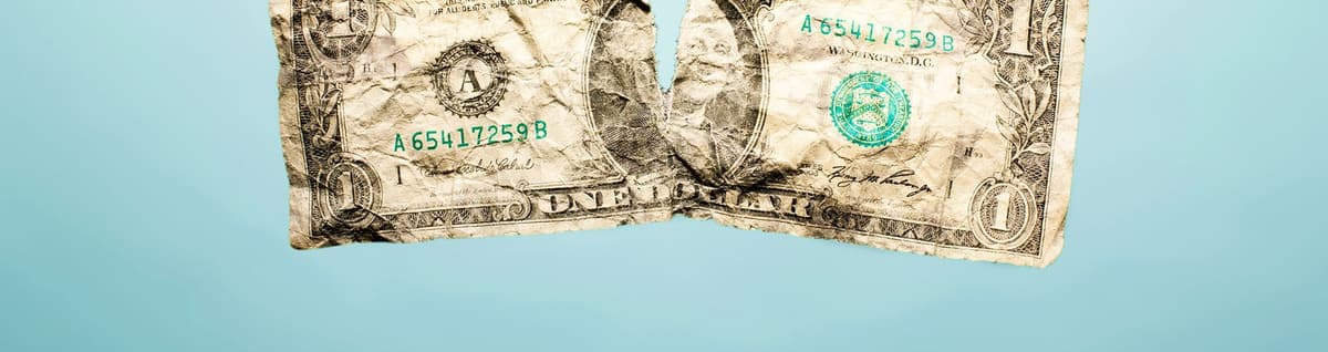 dólar velho rasgado sob fundo azul