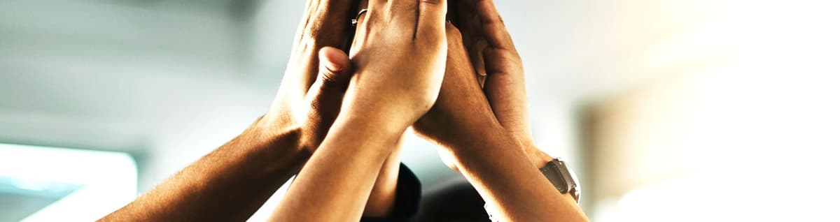pessoas diversas erguendo as mãos em celebração