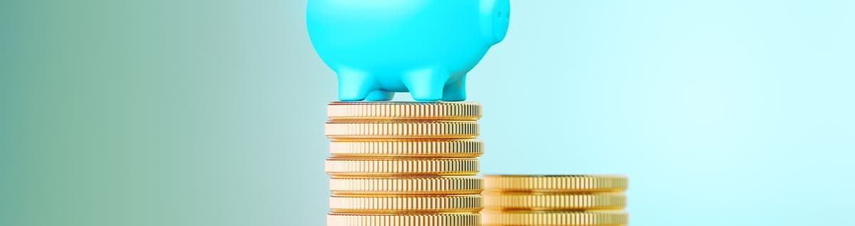 cofre em figura de porco em azul sobre pilhas de moedas