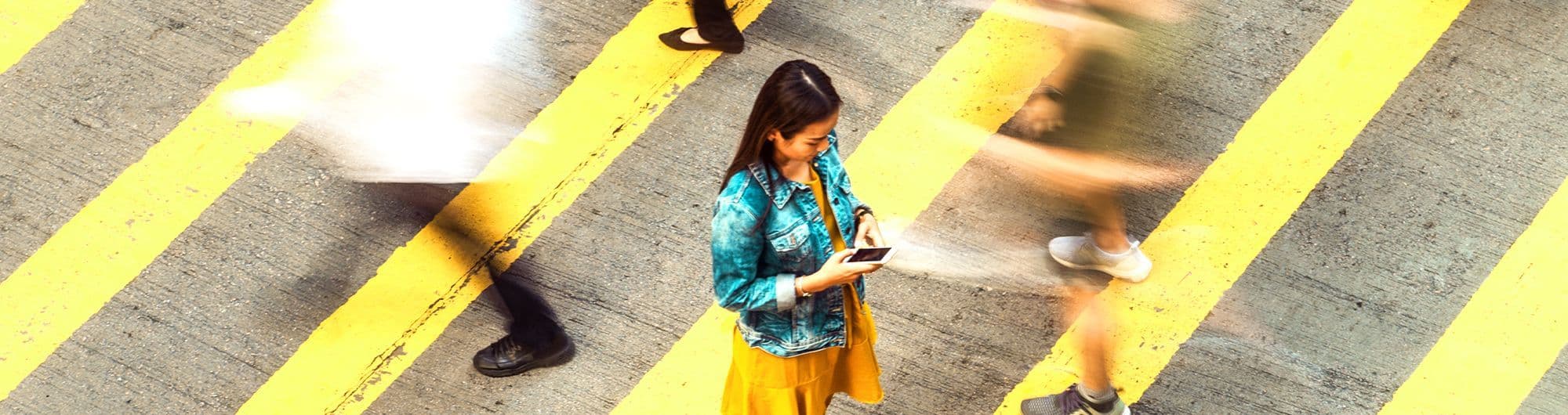 mulher em faixa de pedestre vista superior e pedestres em movimento